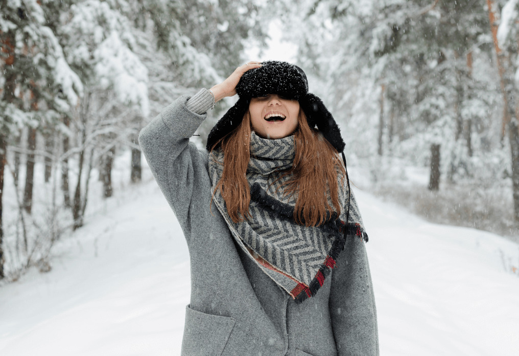 Photographie d'une femme riant sous la neige